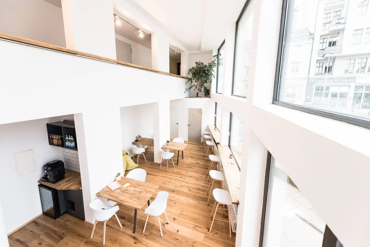 Heller Coworking-Space von COWOS in Berlin-Schöneberg mit Holzboden und Arbeitsplätzen – hier kommt deine Post an